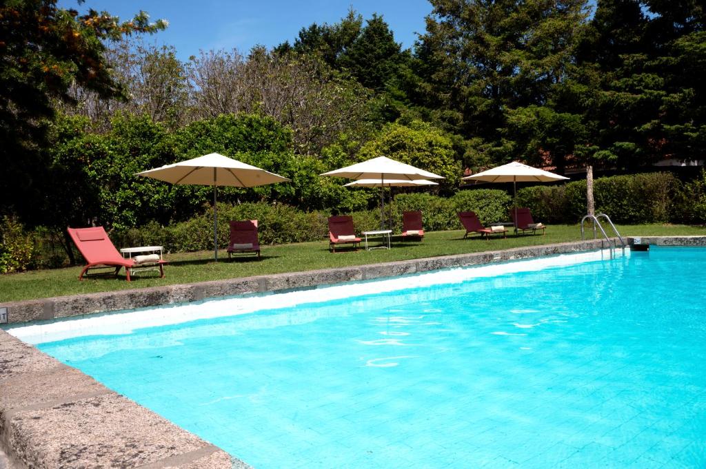 uma piscina com espreguiçadeiras e guarda-sóis em Casa do Ameal em Viana do Castelo