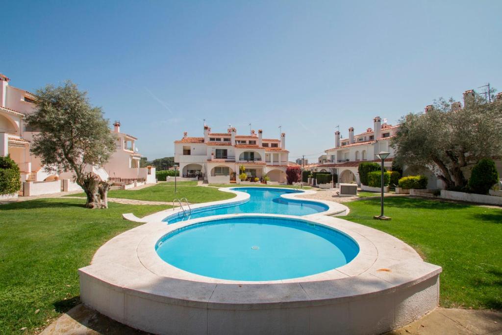 - une piscine dans une cour avec des maisons en arrière-plan dans l'établissement Club Villamar - Palma 2, à Sant Antoni de Calonge