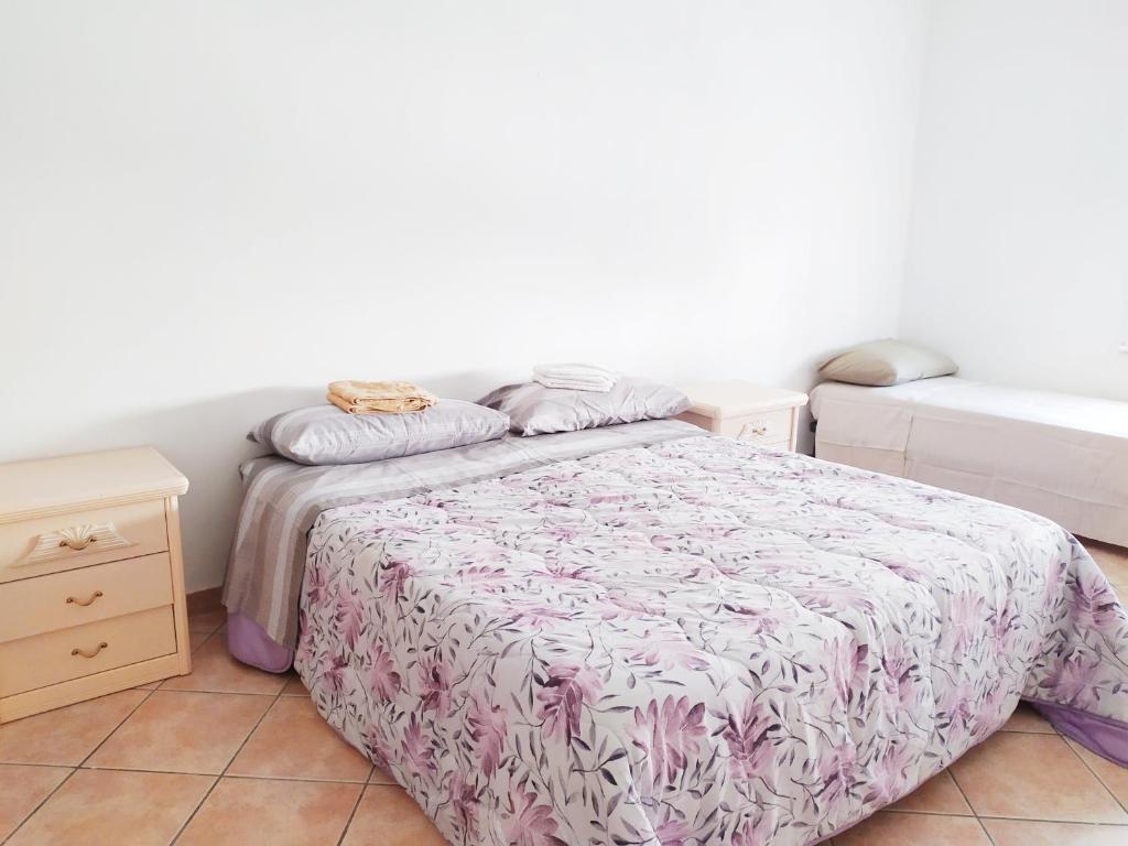 Habitación pequeña con cama y mesita de noche en Levico Centrale Apartment en Levico Terme