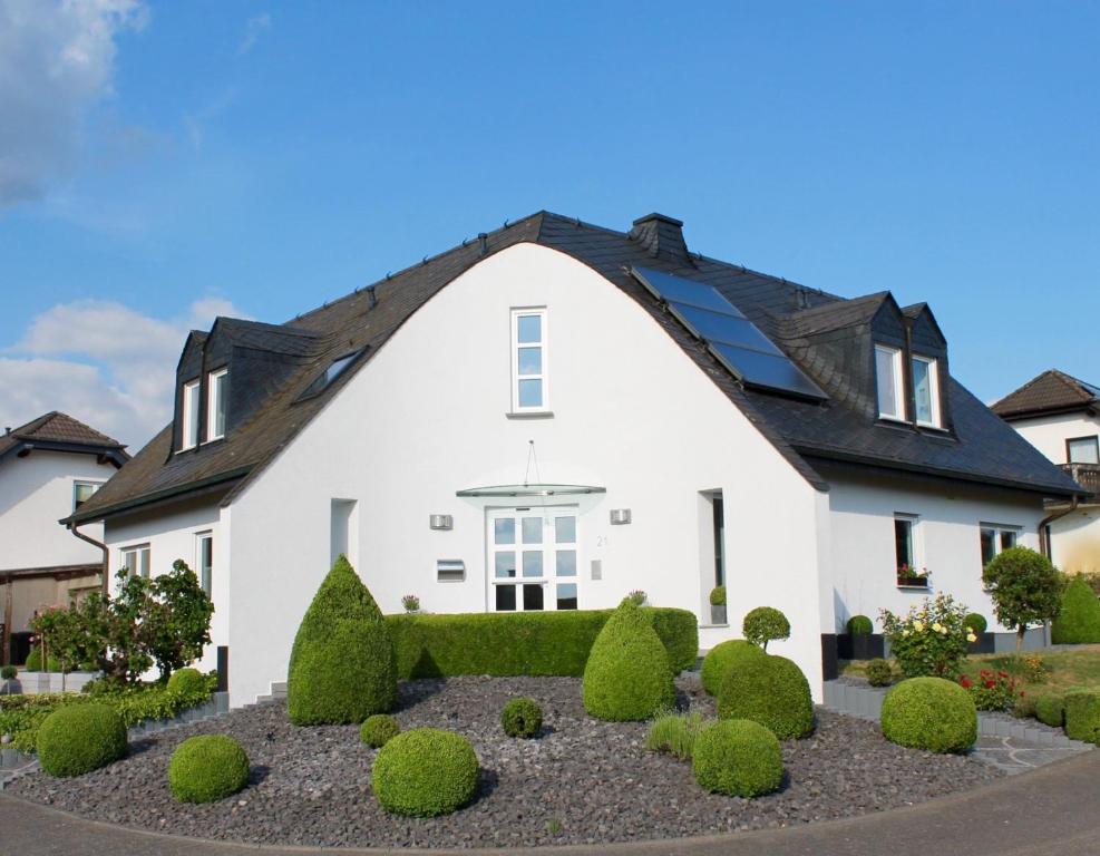 a white house with a black roof at Ferienwohnung auf der Moselhöhe - Nähe Koblenz und Cochem in Dieblich