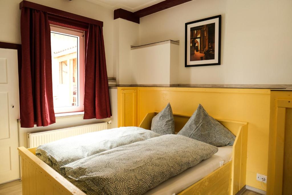 - une chambre avec un lit doté d'oreillers et d'une fenêtre dans l'établissement vakantiehuis Julia, à Bad Sachsa