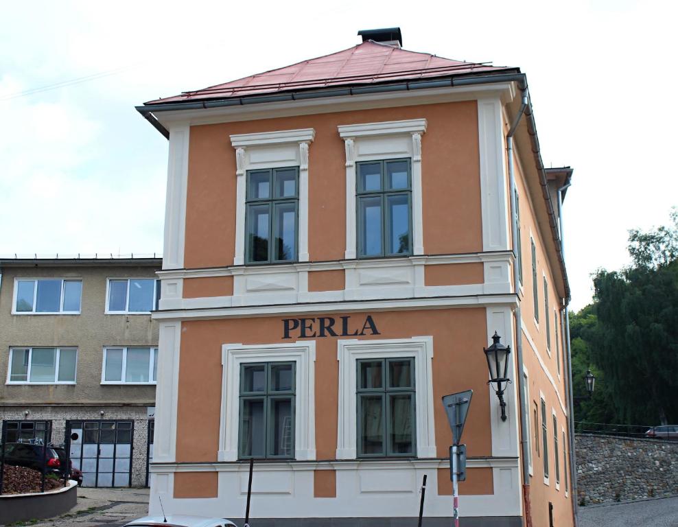 a building with a sign that reads perilla at Apartmány Perla in Banská Štiavnica