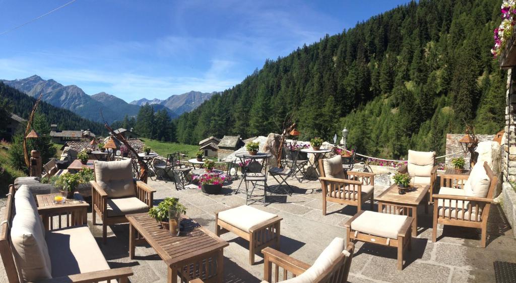 a group of tables and chairs on a patio with mountains at Baita La Jolie Bergere in La Salle