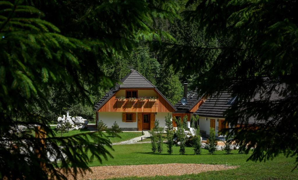 una casa con techo negro en un patio verde en JULIAN VILLAGE LEPENA, en Soča