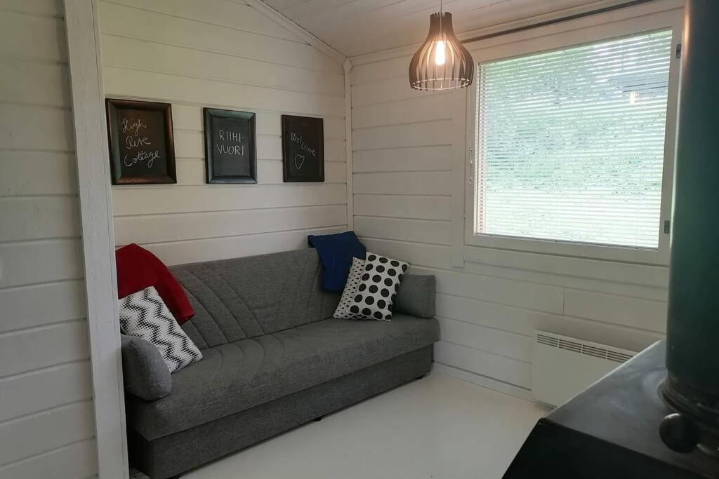 a small living room with a couch in the corner at High Rise Cottage in Muurame