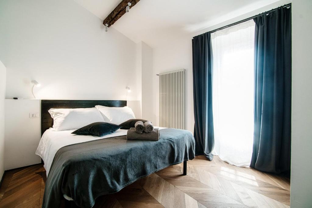 sypialnia z łóżkiem i dużym oknem w obiekcie Caesar Suites - The House Of Travelers w Como