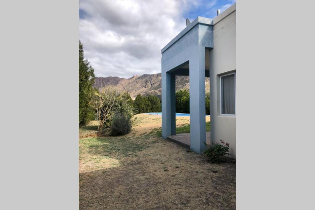 a view of a white house with mountains in the background at Chalet del Valle Grande in Valle Grande