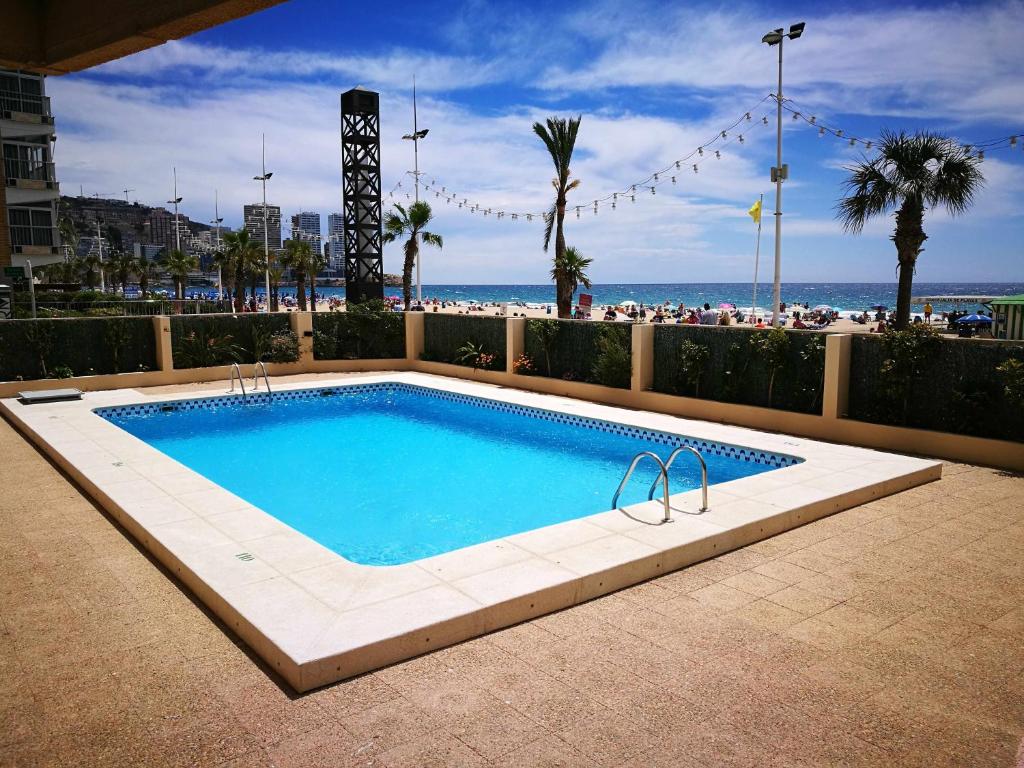 a swimming pool with the beach in the background at Playa de Levante Jazmines 16 in Benidorm