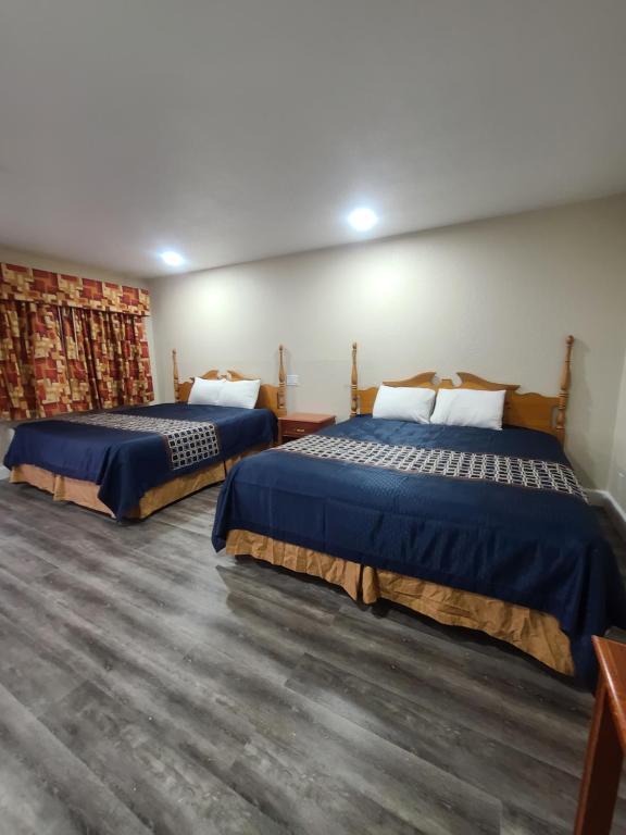 a hotel room with two beds in a room at Majestic Inn & Suites in Klamath Falls