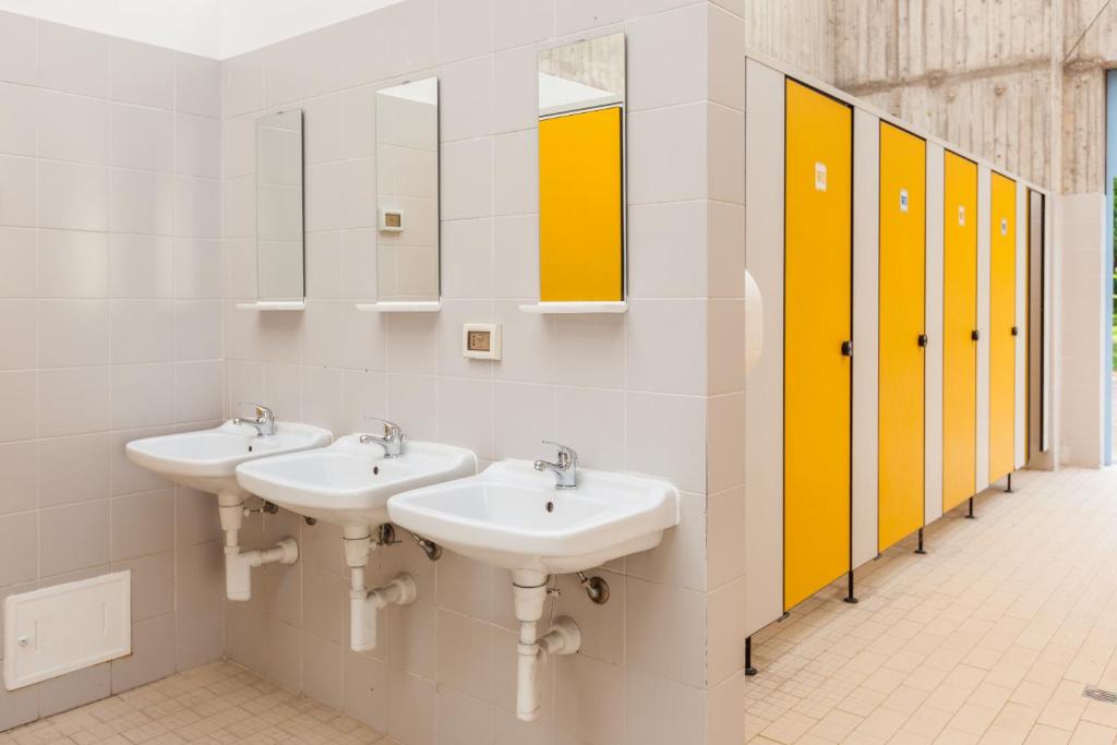 łazienka z 3 umywalkami i 2 lustrami w obiekcie Camping Vicenza w mieście Vicenza