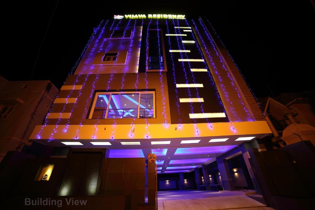 a tall building with lights on it at night at Vijaya Residency - Porur in Chennai
