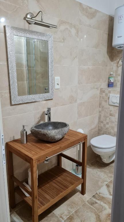 a bathroom with a sink and a mirror and a toilet at Apartments Prižmić in Podstrana