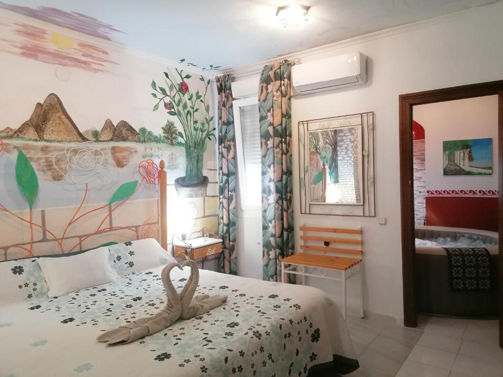 1 dormitorio con 1 cama con una pintura en la pared en Alojamientos Turísticos Centro de Extremadura, en Calamonte
