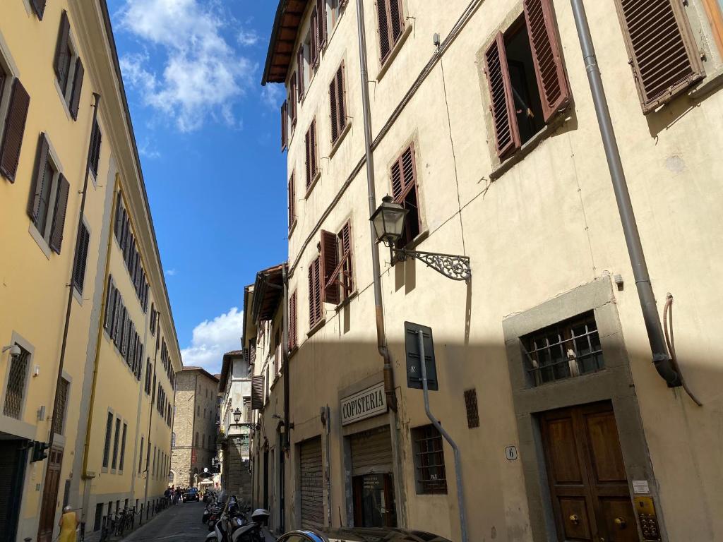 uma rua com um edifício com uma bandeira em Nice & Roomy Apartment behind the Uffizi Museum em Florença