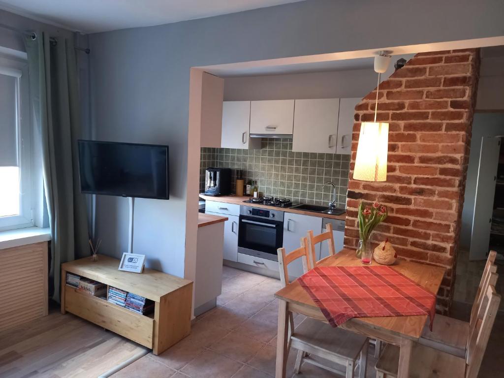 een keuken en eetkamer met een tafel en een televisie bij Apartament Promenada in Częstochowa