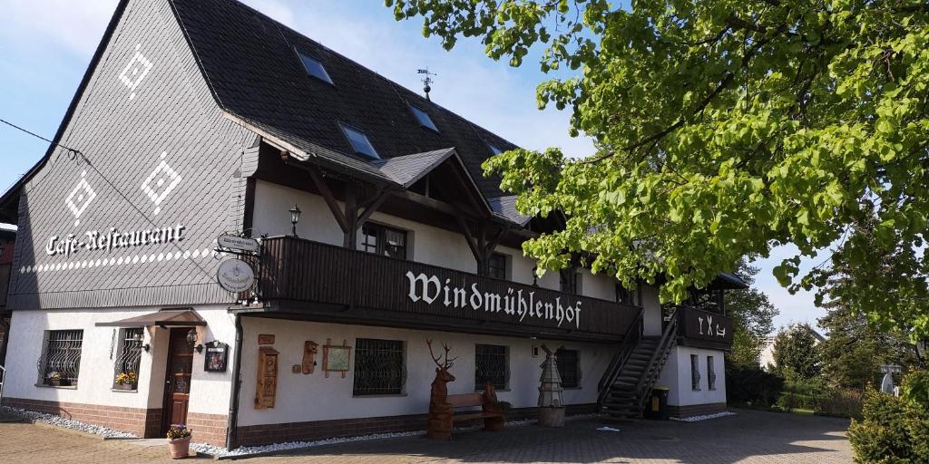 a large white building with a black roof at Windmühlenhof in Dittmannsdorf