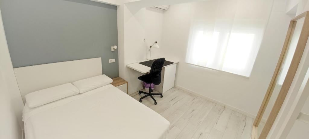 1 dormitorio con cama, escritorio y silla en Hispania House, en Huelva