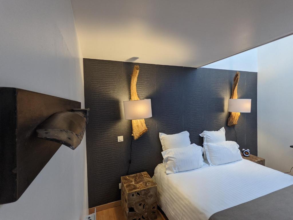 サン・クエンティンにあるGîte La filatureのベッドルーム1室(ベッド1台付)、壁にランプ2つ