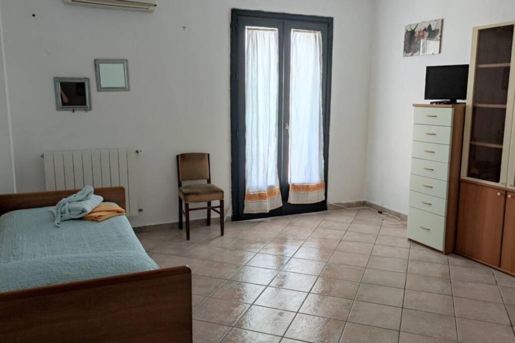 sypialnia z łóżkiem i krzesłem w obiekcie Appartamento incantevole 90 mq a due passi mare mozzafiato w mieście Isola delle Femmine