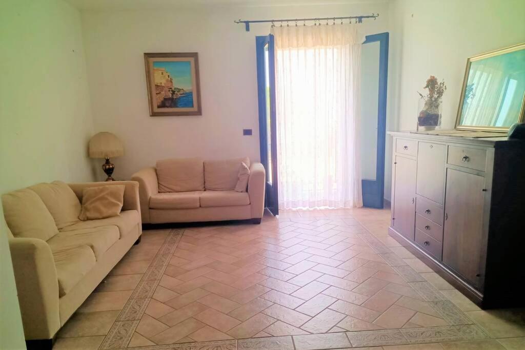 salon z kanapą i krzesłem w obiekcie Appartamento incantevole 90 mq a due passi mare mozzafiato w mieście Isola delle Femmine
