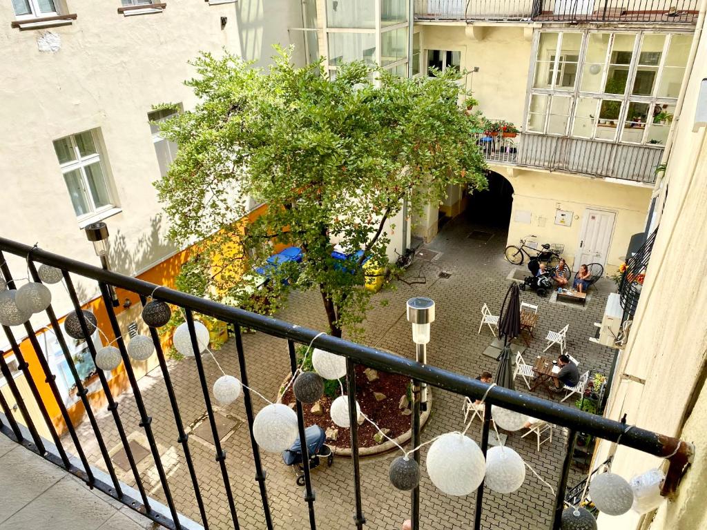 einen Balkon mit Blick auf einen Baum und ein Gebäude in der Unterkunft URBAN JUNGLE Apartment old town Air Conditioned in Bratislava