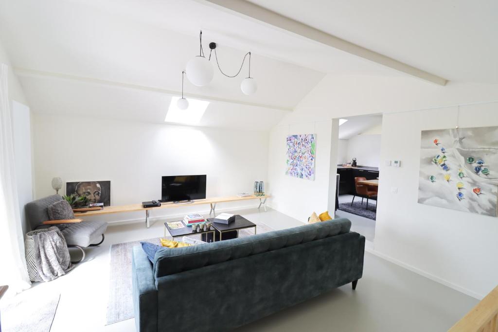 a living room with a couch and a table at Louis Henry Loft in Londerzeel