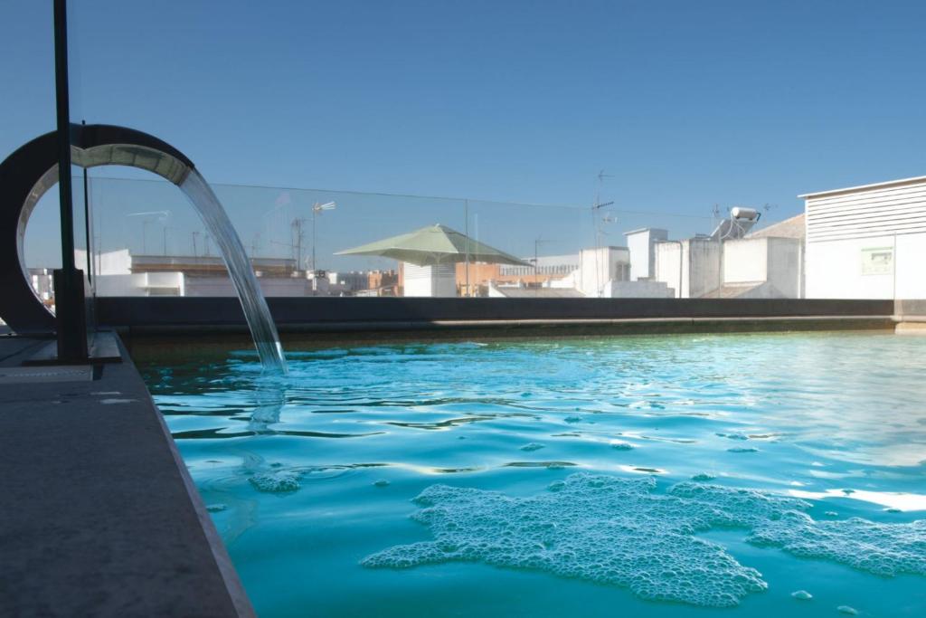 una piscina con una fuente de agua en Holiday Rentals Los Salados en Sevilla