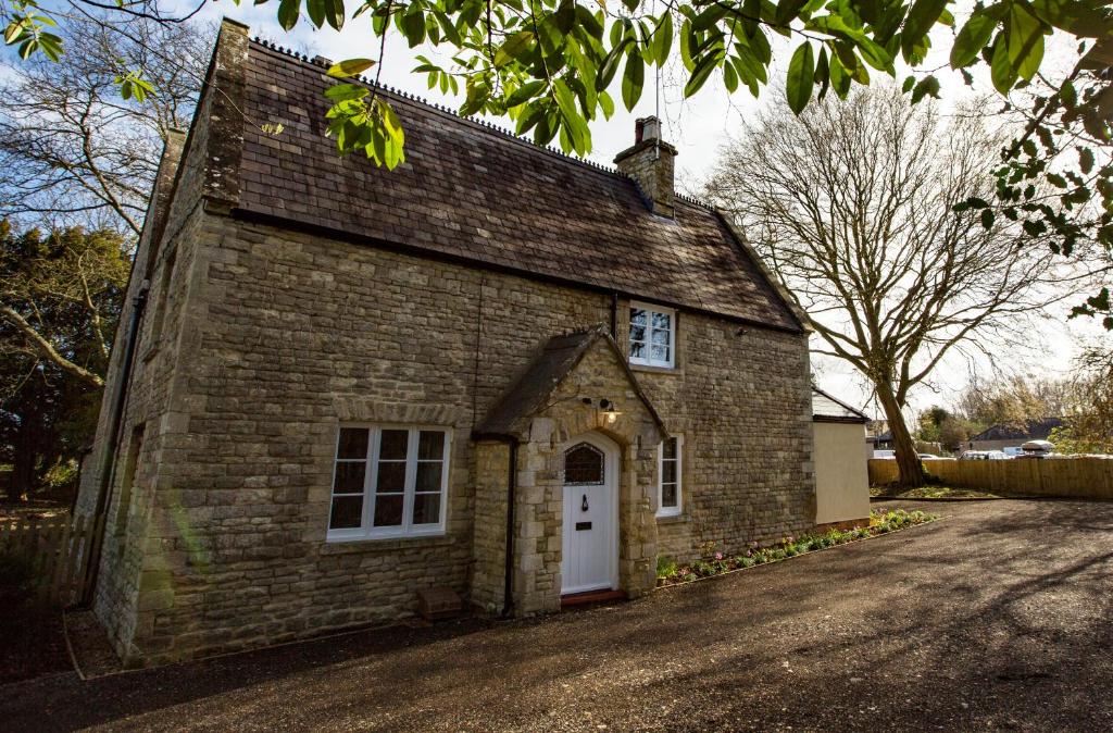 un pequeño edificio de ladrillo con una puerta blanca en Old School Wolverton, en Milton Keynes