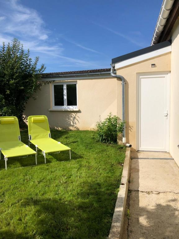 twee gele stoelen in de tuin van een huis bij L’échappée Bulles in Épernay