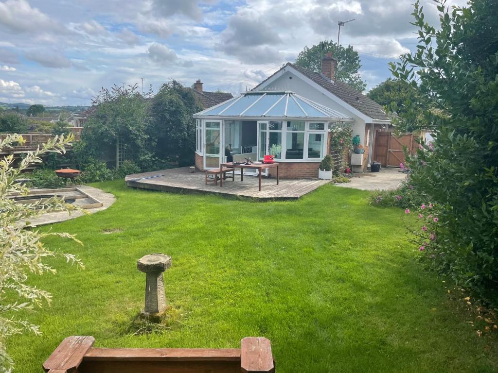 a garden with a house with a bench in the yard at 3 Bed Bungalow in Winchcombe, Cotswolds,Gloucester in Winchcombe