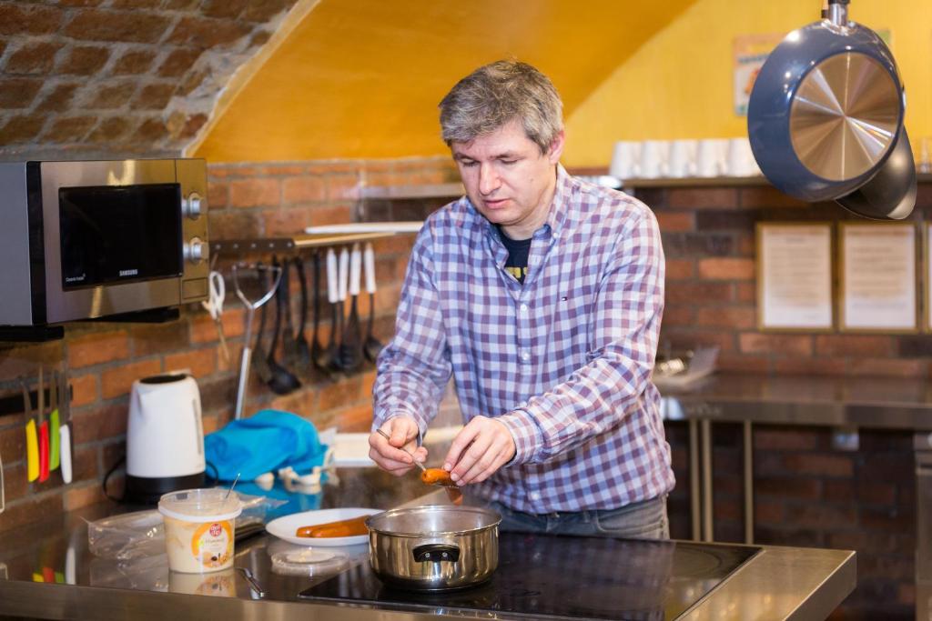 a man standing in a kitchen preparing food at BeFree Hostel - Self-Service in Vienna