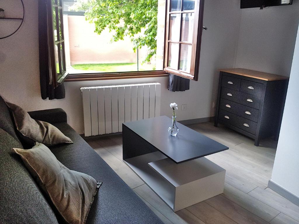 - un salon avec une table basse et une fenêtre dans l'établissement Studio de la Tour des rondes - tout confort plein-centre, à Lavaur