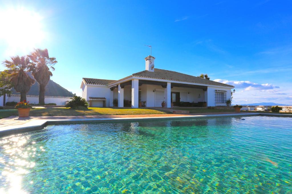 une grande piscine en face d'une maison dans l'établissement LAS BREÑAS Premium Rural Cottage 4PAX, à Alhaurín de la Torre