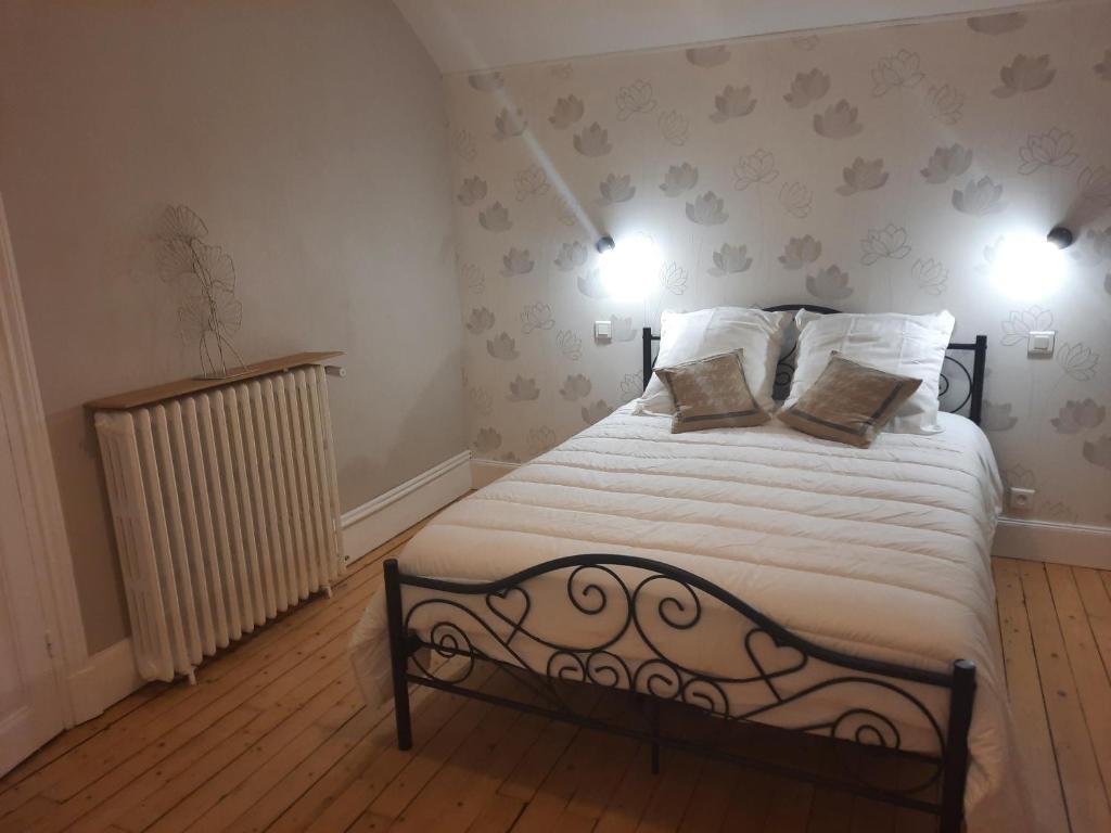 a bedroom with a bed with two pillows on it at Chambre d'hôtes LE PUITS DARCY in Montceau-les-Mines