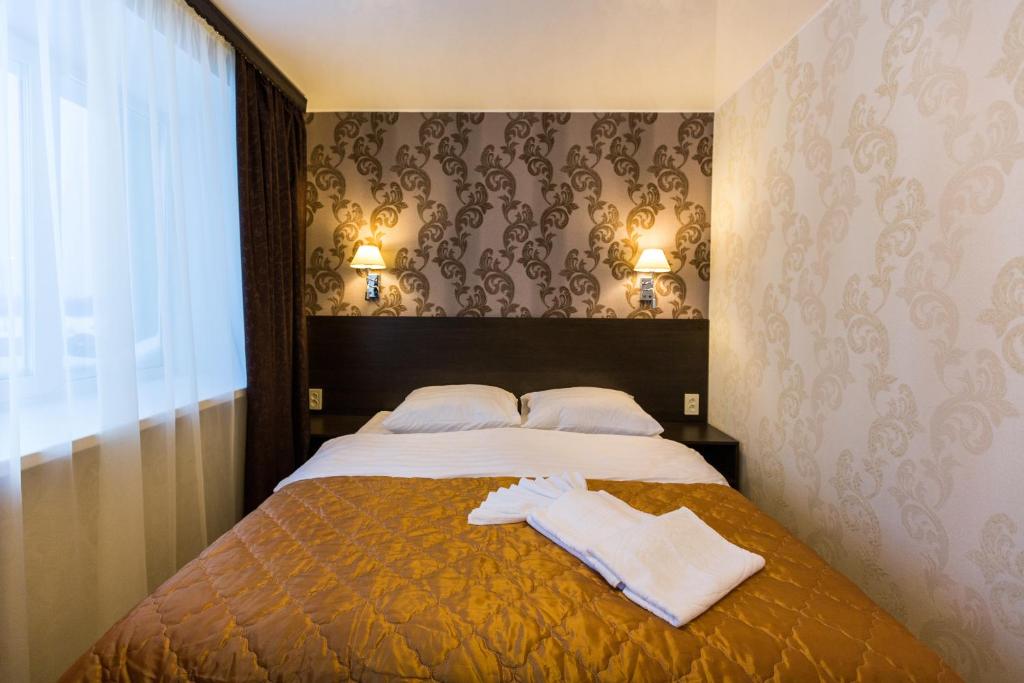 1 dormitorio con 1 cama con 2 toallas en Siyaniye Hotel, en Syktyvkar