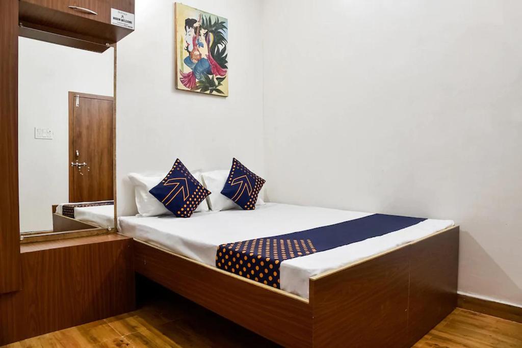 un letto con cuscini blu e bianchi in una stanza di Hotel Saubhagya a Bhopal