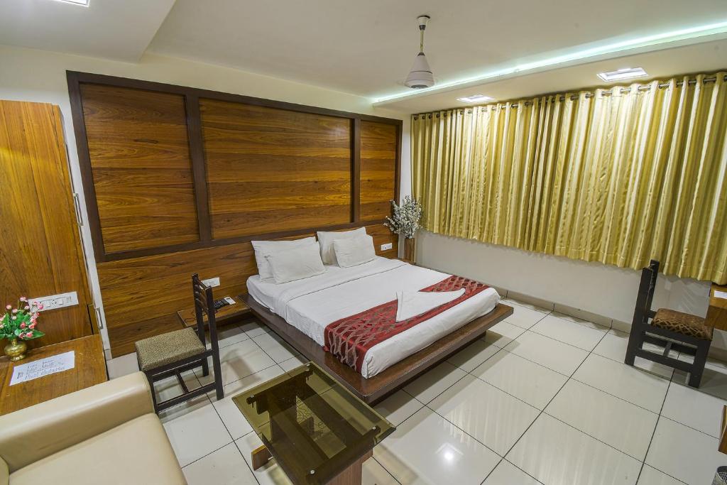 1 dormitorio con cama, sofá y mesa en Hotel Radiant en Kolhapur