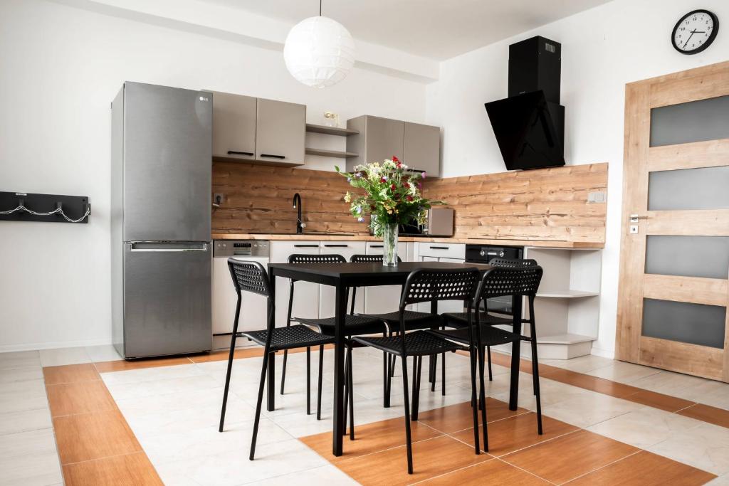 a kitchen with a black table and black chairs at Apartmán v Žacléři Krkonoše in Žacléř