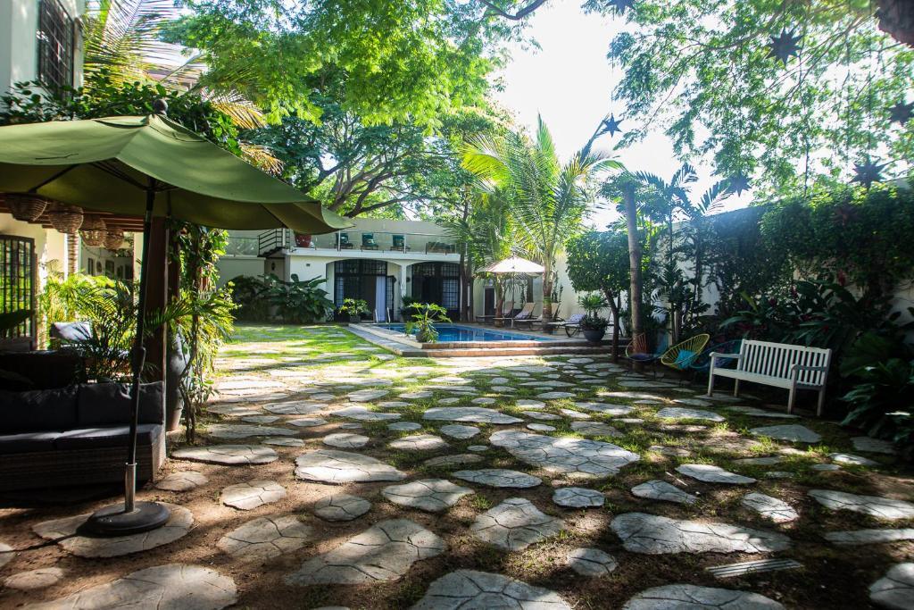 una pasarela de piedra con una sombrilla frente a una casa en Villas Parota Inn en Nuevo Vallarta 