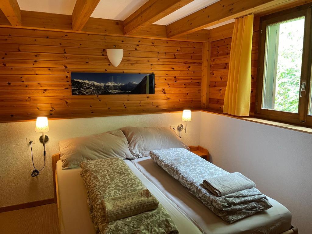 a bedroom with a bed with a tv on the wall at Chalet Sonnenröschen in Blatten bei Naters