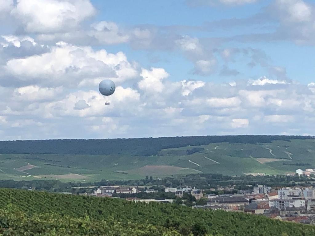 a balloon flying in the sky over a city at L’échappée Bulles in Épernay