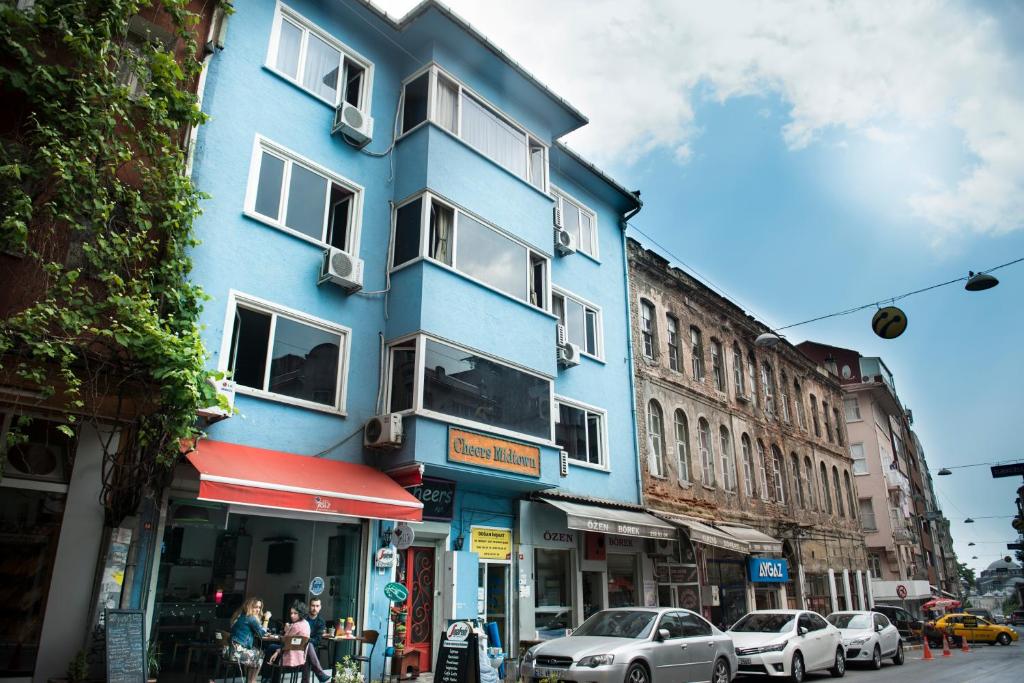 a blue building on a city street with parked cars at Cheers Midtown Hostel in Istanbul