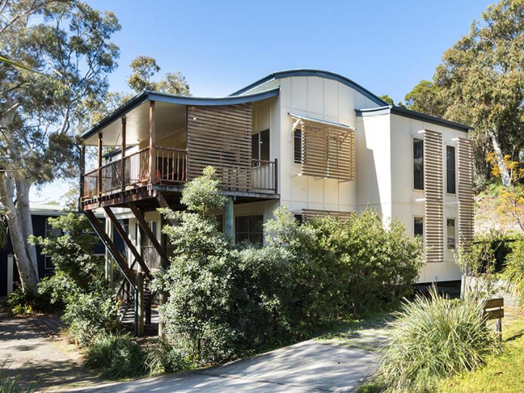 a large white building with a porch and balcony at Absolute in Point Lookout