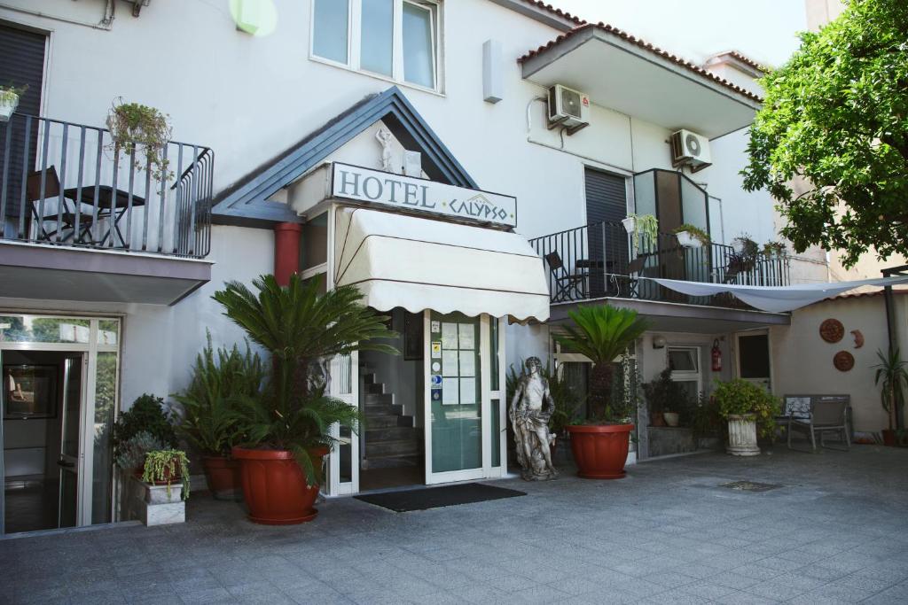 un hotel con plantas frente a un edificio en Hotel Calypso, en Pompeya