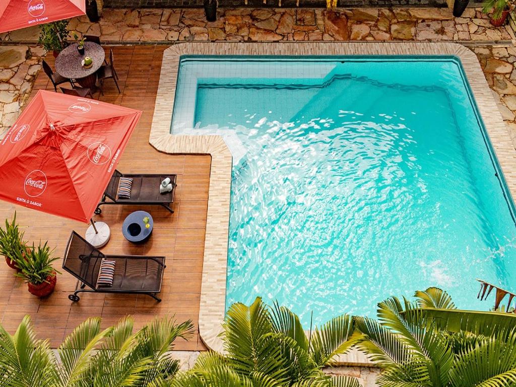 una vista aérea de una piscina con dos sombrillas en Recanto da Orla, en Aracaju