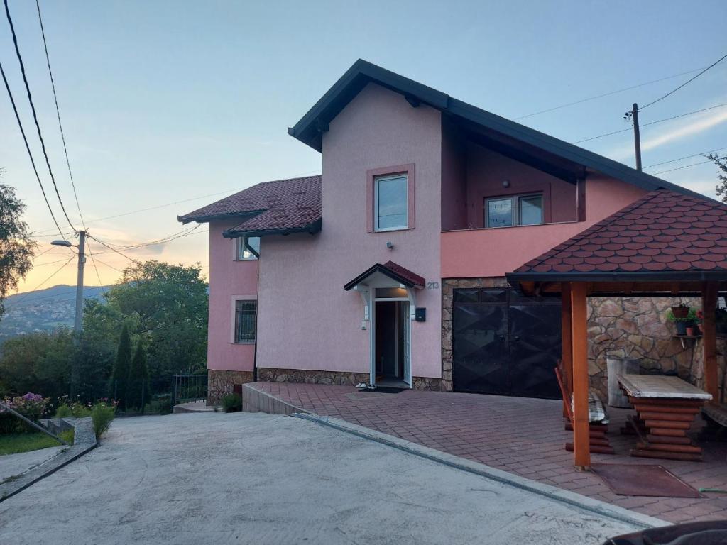 ein rosa Haus mit Garage davor in der Unterkunft Villa Amir in Sarajevo