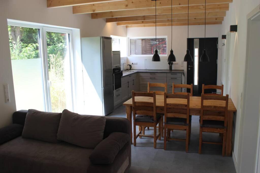 - une cuisine et une salle à manger avec une table et des chaises dans l'établissement Ferienwohnung - Monteurunterkunft 31188 Holle, à Holle