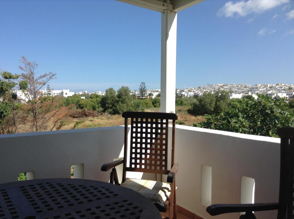 a balcony with a table and a view of a city at Astir Of Naxos in Naxos Chora
