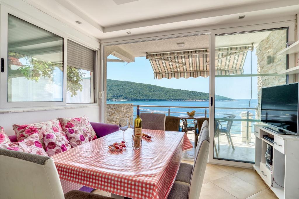 a living room with a table and a view of the ocean at Odore di Mare in Utjeha