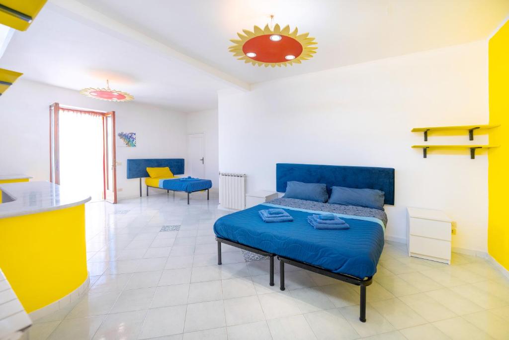 ein Schlafzimmer mit einem Bett und ein gelb-weißes Zimmer in der Unterkunft Margherita House in Procida